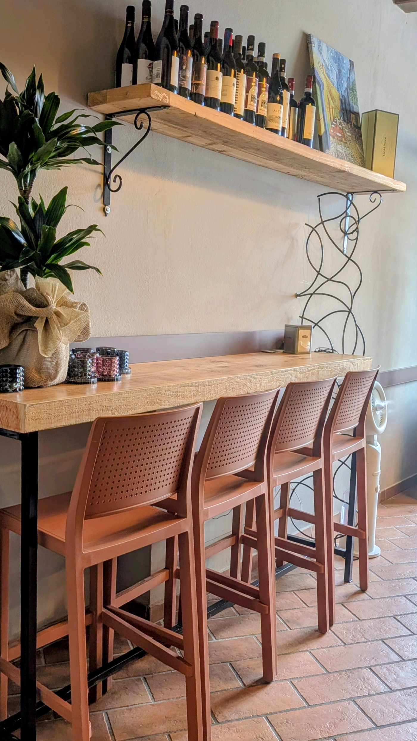 Wine bar counter with high stools at Le Cinque Lune taverna, Pienza
