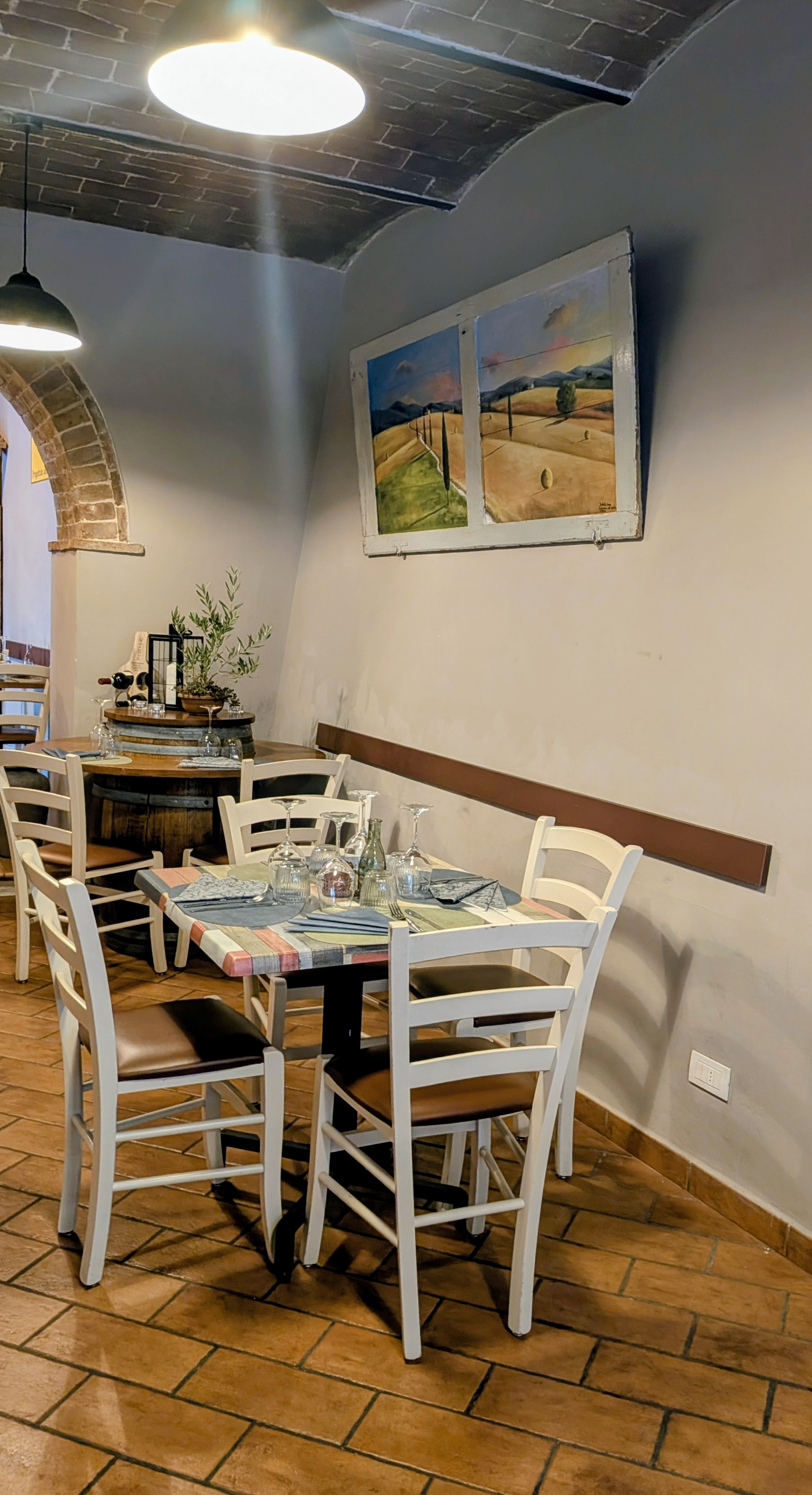 Sala taverna con arco in pietra e quadro Val d'Orcia